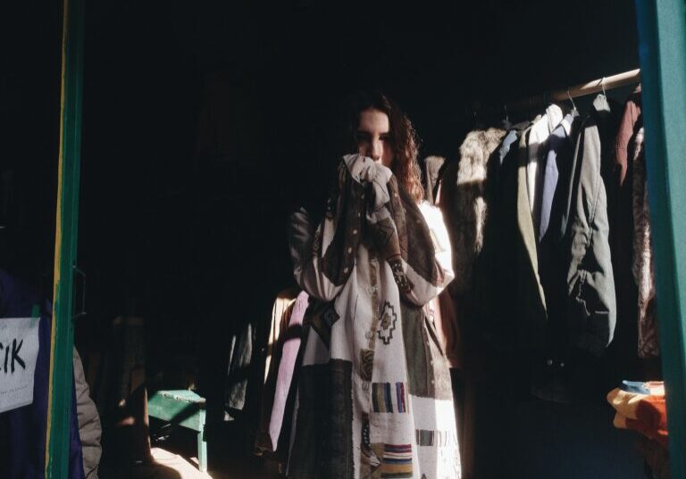 Anxious Woman beside Clothing Racks